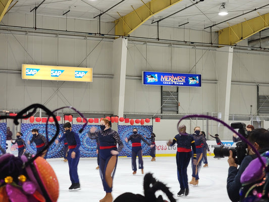 Navy synchronized skating team show costumes with red sash SAP Center performance