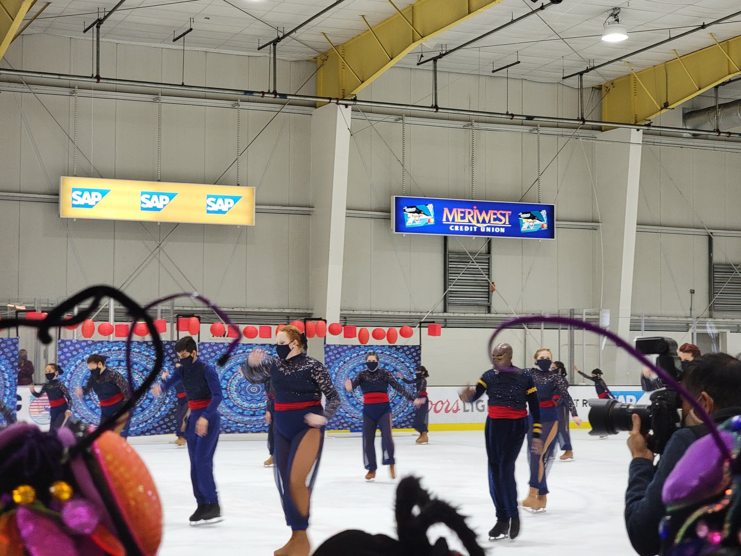 Navy synchronized skating team show costumes with red sash SAP Center performance